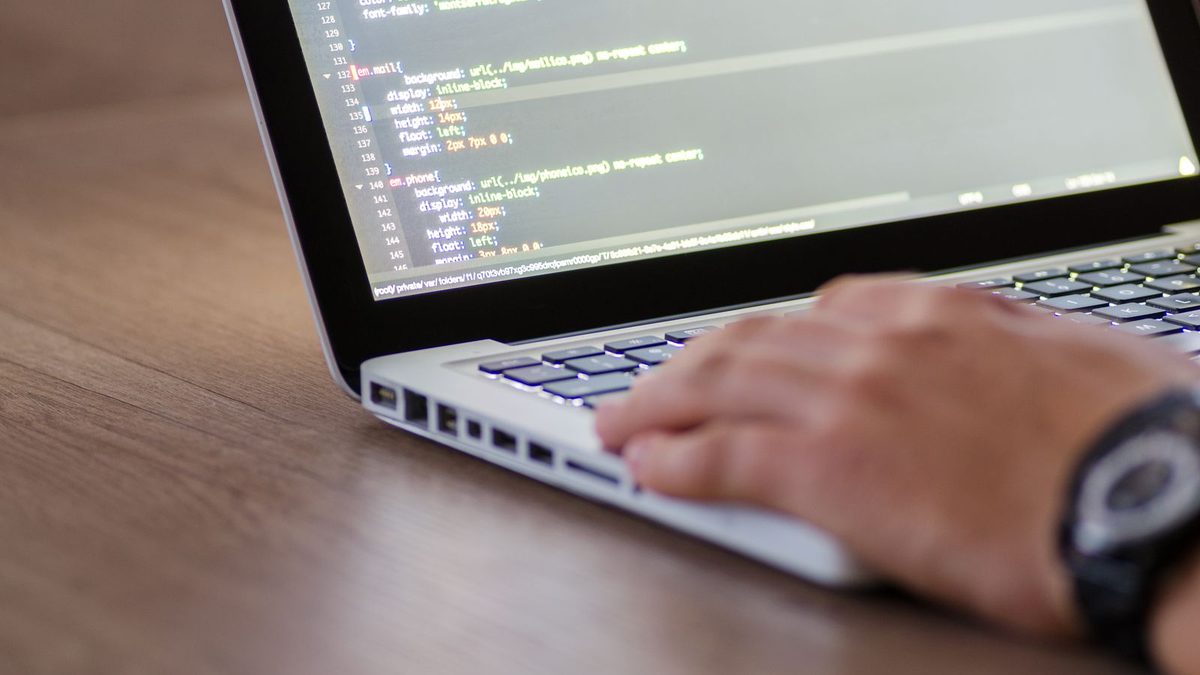 A developer working on a laptop, maintaining a live app after launch