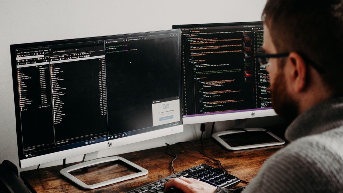 A developer working across screens on app maintenance and monitoring