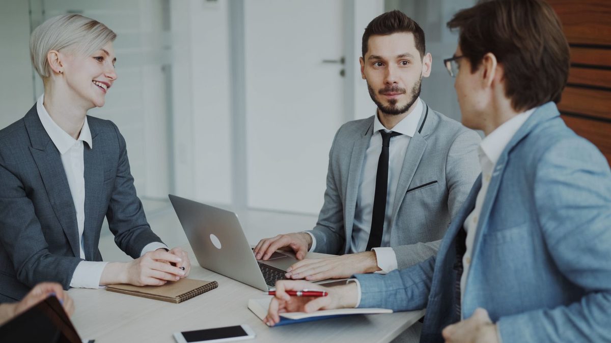 A team in a scoping meeting discussing an app around a laptop
