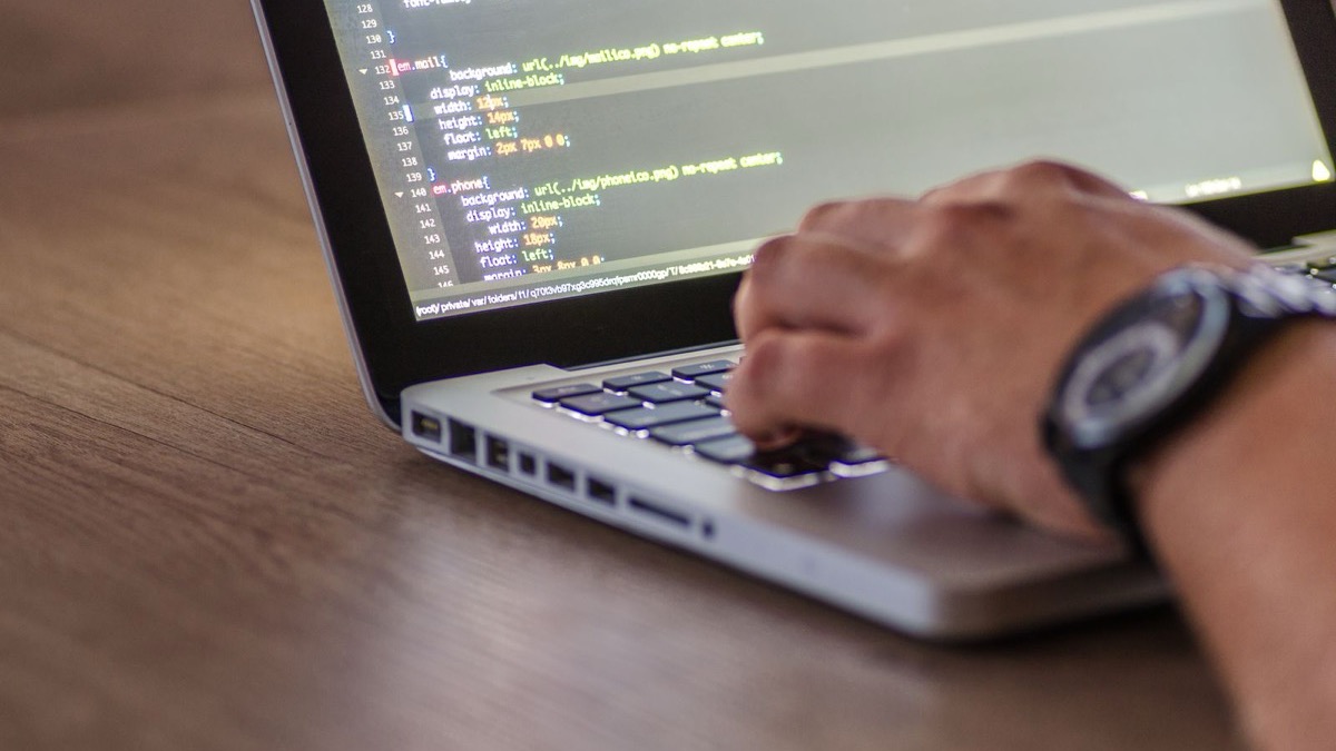 Developer comparing code architecture on multiple screens while planning a cross-platform mobile app