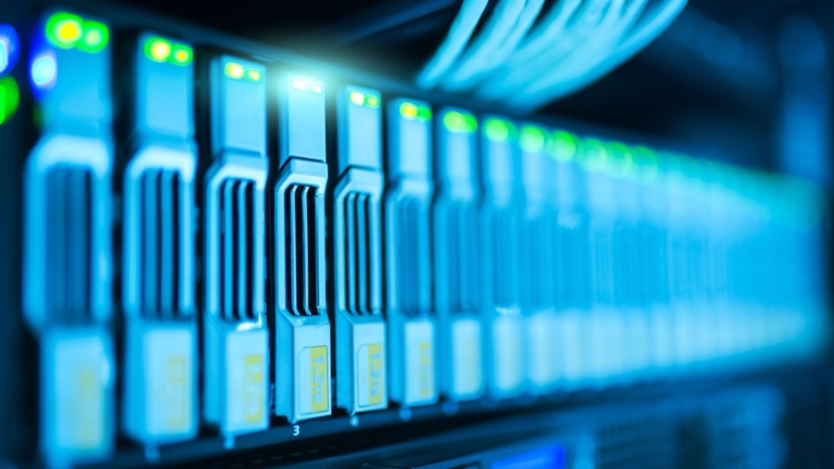 A blue-lit server rack showing a row of drive bays with green status lights and bundled cabling